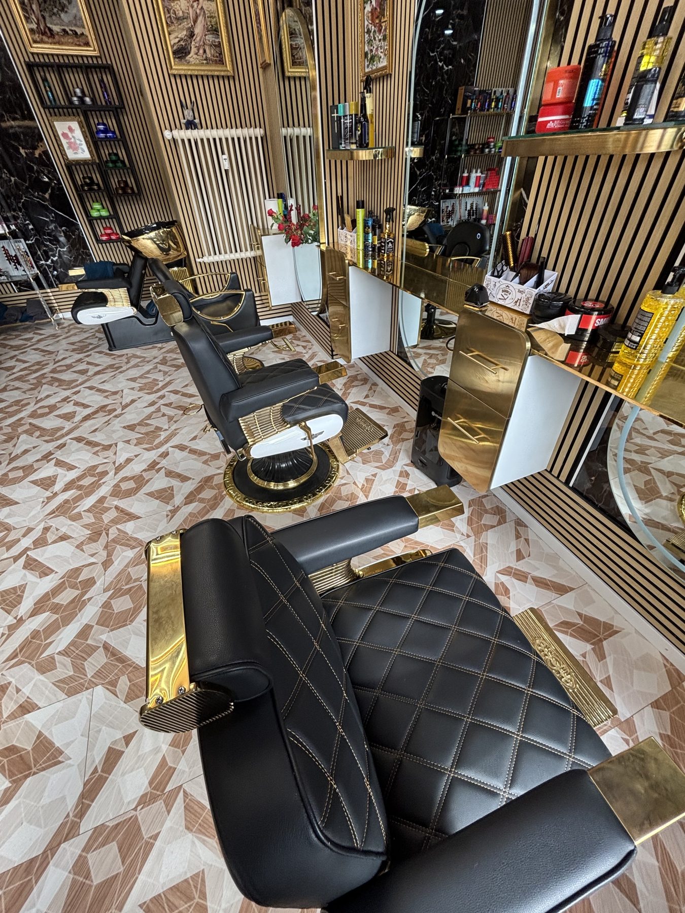 Fauteuil de coiffure noir capitonné, pied doré